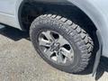 Close-up of a 2014 Ford F-150 tire showing a rugged tread pattern and a modern alloy wheel design