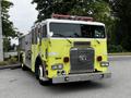 A 1995 Freightliner FLL086 fire truck featuring a bright yellow body chrome front grille and roof-mounted emergency lights