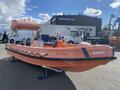 A 2007 Fassmer 20 Foot Fast Rescue Boat in orange with a canopy and seating for several passengers, featuring the text "COASTAL INSPIRATION VICTORIA" on the side