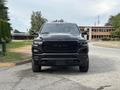 A black 2021 RAM 1500 pickup truck is facing forward with a bold grille featuring the RAM logo and sleek headlights