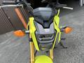 A 2018 Honda Grom with a bright yellow frame features a compact design, prominent headlight, and orange turn signals.
