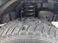 Close-up of a tire and suspension system from a 2008 Ford Econoline showing tread pattern and coil spring structure
