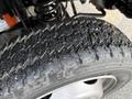 Close-up of a worn tire on a 2015 Ford F-550 showcasing deep tread patterns and some dirt buildup on the surface
