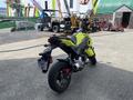 A 2018 Honda Grom motorcycle in a bright yellow color with a compact design and distinctive styling features including a small frame and sporty appearance