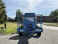 A blue 2012 Genie Z 45/25 aerial lift with large rubber tires and a metal platform at the front is depicted from the rear