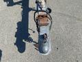 A close-up of the hitch of a 2013 Larson 238 boat trailer showing a metal coupler with a safety latch and a wire harness attached to it