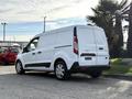 A white 2020 Ford Transit Connect van parked with a sleek design and a spacious cargo area visible from the rear angle