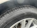 Close-up of a 2018 Ford Focus tire showing detailed tread pattern and rim design with slight water droplets on the surface