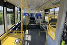 Interior of a 2017 Grande West Vicinity bus featuring blue and yellow seats yellow handrails and accessible spaces