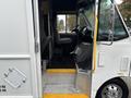 A 2012 Ford E-450 Super Duty with a spacious cabin featuring driver and passenger seats and a step entrance into the vehicle