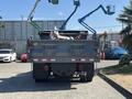 A 2016 RAM 5500 truck with a flatbed and rear loading mechanism facing forward