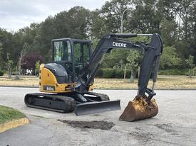 A 2017 John Deere 50G excavator with a black arm and a metal bucket is positioned on a flat surface ready for excavation activities