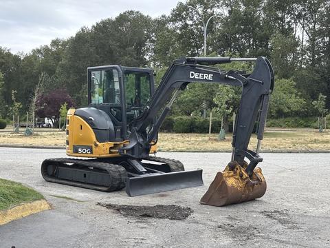 A 2017 John Deere 50G excavator with a black arm and a metal bucket is positioned on a flat surface ready for excavation activities