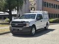 A 2019 Ford F-150 pickup truck in white with a black front grille and utility cap on the bed