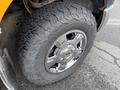 A close-up view of a chrome wheel and rugged tire of a 2014 Ford F-150 showcasing the tire's tread pattern and wheel design