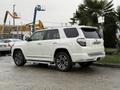 A white 2018 Toyota 4Runner parked with a sleek design and modern features including a rear spoiler and multi-spoke alloy wheels