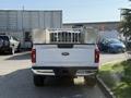 A 2021 Ford F-150 truck in white with a metal bed rack attached to the rear