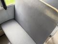 A gray upholstered bench seat typical of a 2013 International 4300 bus with a clean and simple design