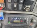 Control panel of a 2012 John Deere 310SJ displaying gauges and switches with readings on a screen
