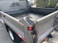 A 2013 RAM 5500 flatbed truck with a metal bed and tailgate equipped with a latch and a red tail light
