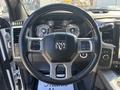 A 2018 RAM 3500 steering wheel with controls and the RAM emblem prominently displayed in the center