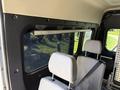 Interior view of a 2021 RAM Promaster with two gray chairs and a light bar mounted above the windows