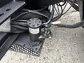 A manual house valve and bypass mechanism mounted on a truck chassis with wires and hoses connected