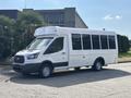 A 2018 Ford Transit-350 bus with a white exterior featuring large windows and a raised roof parked on the street