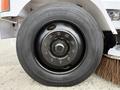 A black wheel with a prominent hub and tire markings mounted on a vehicle