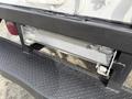 The rear step of a 2008 International CityStar truck featuring a textured surface and a metal frame with a roll-up mechanism