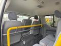 Interior view of a 2009 Toyota Hiace showing gray seats with a yellow safety bar separating the back row from the front
