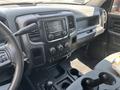 Interior of a 2013 RAM 2500 featuring a dashboard with a touchscreen display and various control knobs along with cup holders and a steering wheel