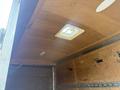 Interior view of a 2016 Continental cargo trailer featuring a wooden ceiling and a small overhead vent with a yellow frame