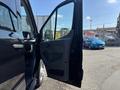 A 2025 Ford Transit T-350 with the driver's side door open, showcasing the interior features and seating arrangements