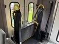 Interior view of a 2014 Ford Econoline showing a folding wheelchair ramp with yellow handles and a storage area for the ramp