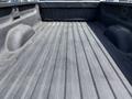 The image shows the bed of a 2016 Chevrolet Silverado 2500HD with a textured black liner and visible ridge patterns