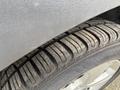 A close-up of a tire on a 2014 Ford Escape showing the tread pattern and some dirt on the surface