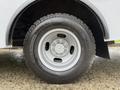 A close-up view of a silver wheel with a large, rugged tire on a 2020 Chevrolet Express van showcasing the wheel design and tread pattern