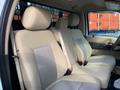 The interior of a 2013 Ford F-450 SD featuring beige cloth seats with a textured center panel and seat belts