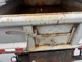A rusted 2011 Dodge Ram 5500 truck bed with a metallic tailgate and a chain securing the latch