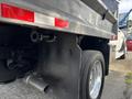 A 2013 RAM 5500 truck with a dump bed is shown from a low angle highlighting the wheel and exhaust system