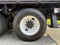 Close-up of a Goodyear tire mounted on a white rim from a 2011 International 7500 truck showcasing the tread pattern and bolt design