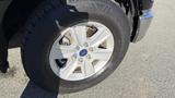 A close-up view of a silver alloy wheel on a 2016 Ford F-150 showcasing the tire tread and wheel design