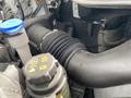 Close-up view of a 2019 Ford Transit engine component featuring a black rubber intake hose and a blue coolant reservoir cap