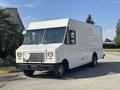 A white 2012 Ford E-450 delivery truck with a flat front and large cargo area parked on a driveway