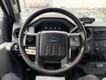 A 2013 Ford F-450 SD steering wheel with the Ford emblem visible and dashboard controls in the background