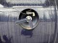 A close-up of a circular valve mechanism on a 2018 Kenworth T800 with a lever and visible residue on the surface