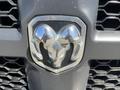 The front grille emblem of a 2015 RAM 1500 featuring a chrome two-tone design shaped like a ram's head