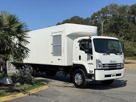 A 2024 Isuzu FVR truck with a white box cargo area and a silver front grille parked on a roadway