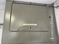 A gray metal compartment door with a G5 logo and a warning label attached to the foreground